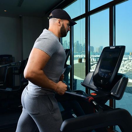 Mina Hotel And Residences By The Torch 도하 외부 사진 A man exercising on a treadmill