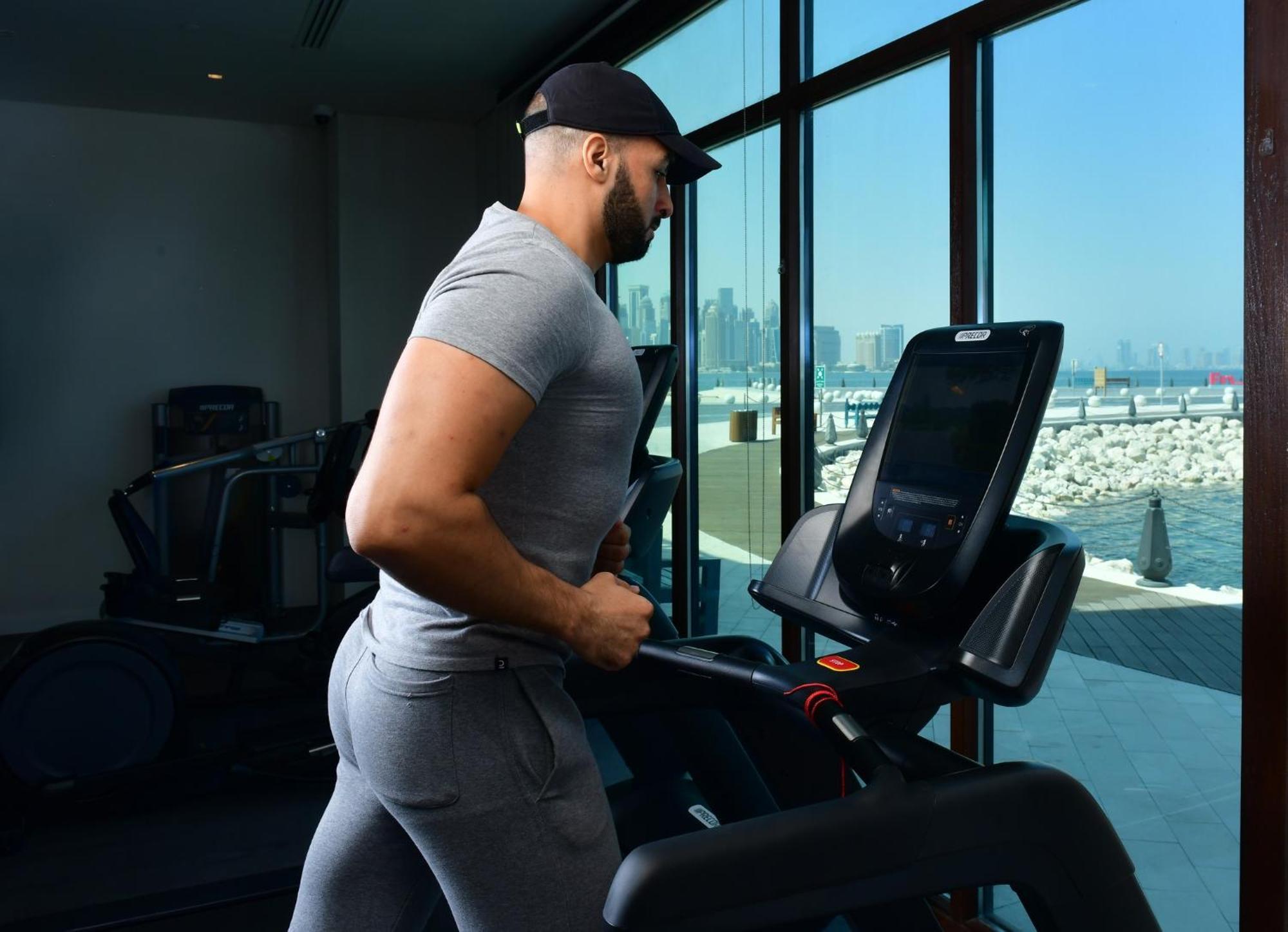 Mina Hotel And Residences By The Torch 도하 외부 사진 A man exercising on a treadmill